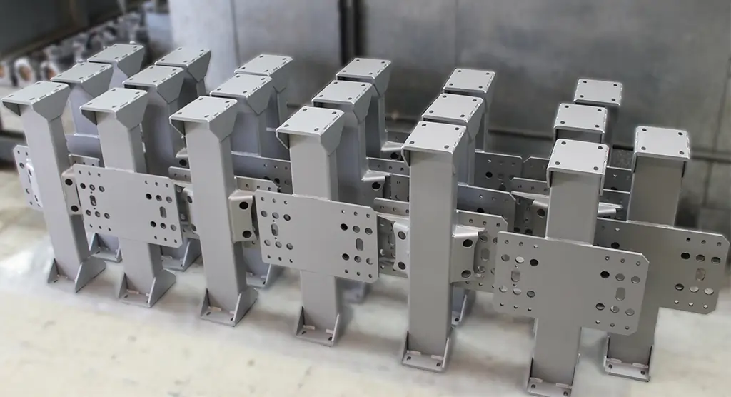 Mehrere lackierte Metallstreben, aufgereiht zur Trocknung nach dem Beschichten.