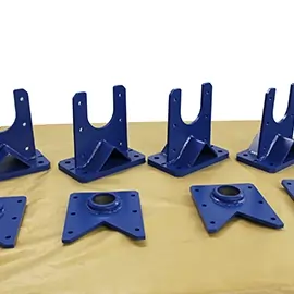 Acht blau lackierte Metallbauteile auf einer Werkbank, bereit zur weiteren Montage.